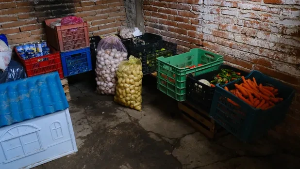 Cajas, costales y alimentos almacenados dentro de un espacio de la finca.