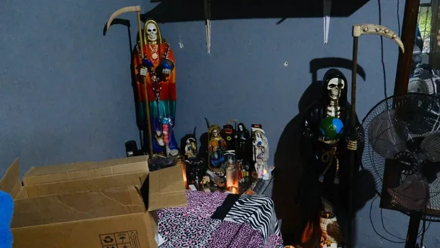 Altar con figuras religiosas y objetos dentro de la finca.